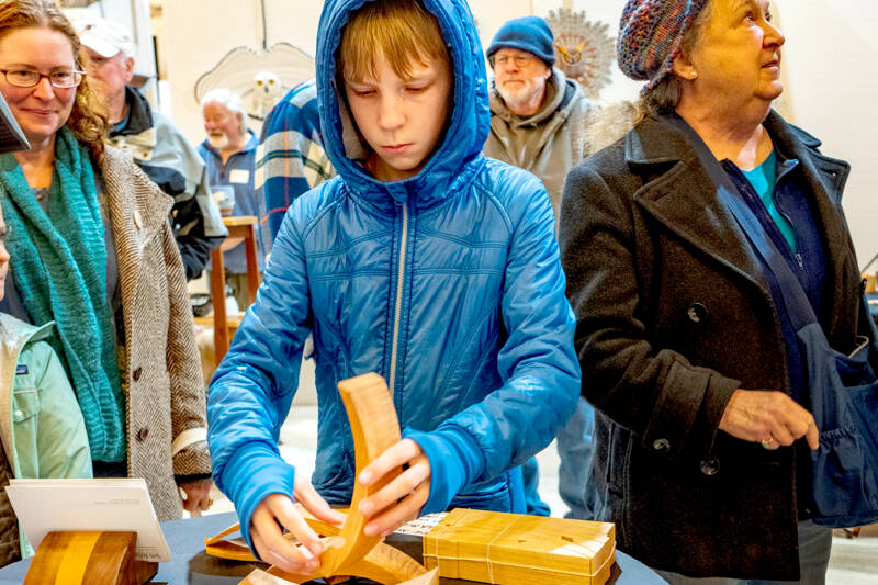 Byron Eisele, 13, of Port Townsend, assembles a build-your-own sculpture from a kit made by Seth Rolland while at the 20th annual Port Townsend Woodworkers Show at the American Legion Hall last weekend. (Steve Mullensky/for Peninsula Daily News)