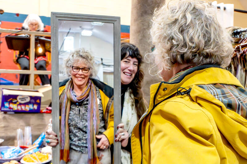 Kendra Russo of Found and Foraged Fibers in Anacortes holds a mirror as Jayne Johnson of Sequim tries on a skirt during a craft fair on Saturday in Uptown Port Townsend. (Steve Mullensky/for Peninsula Daily News)
