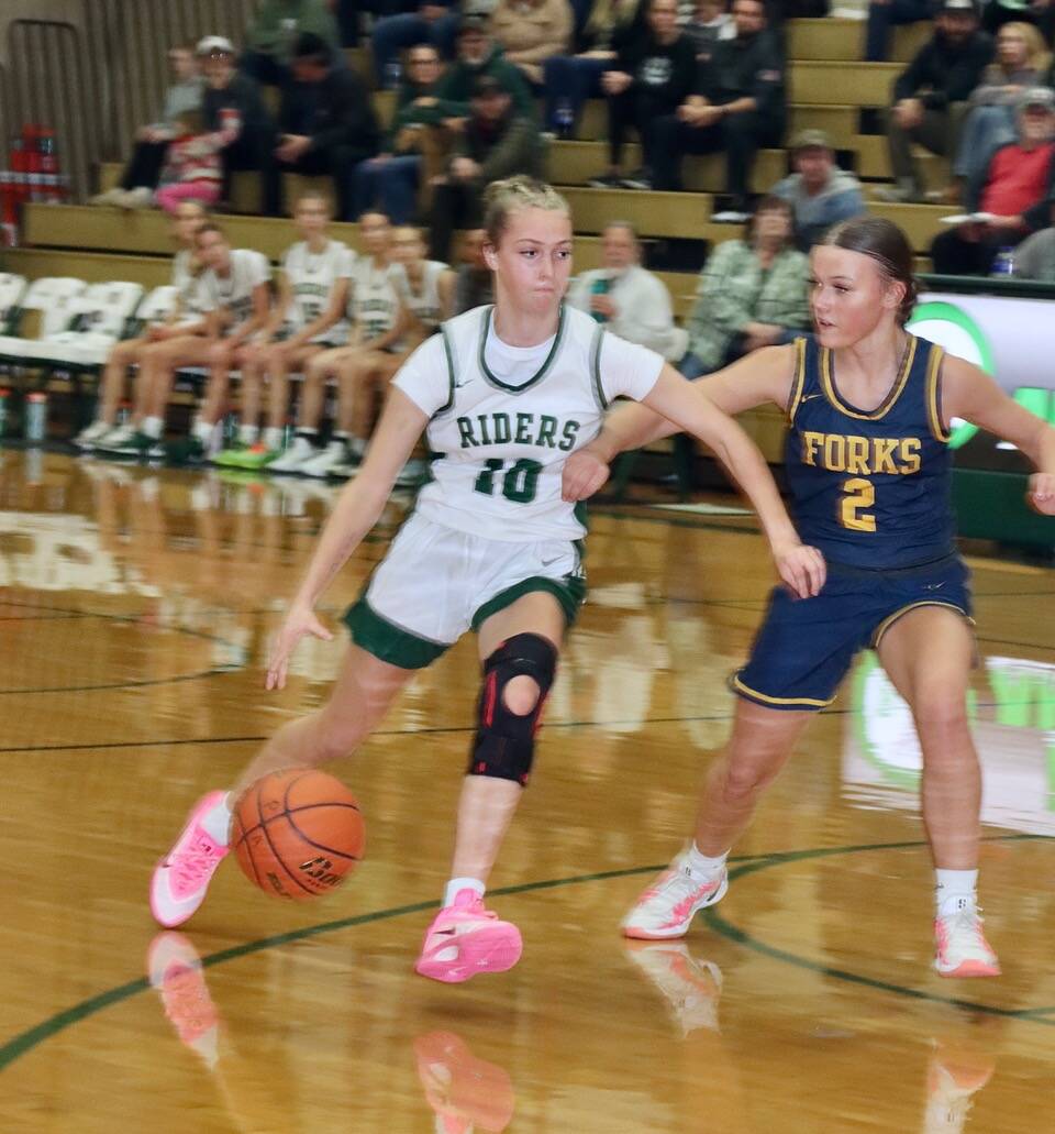 Dave Logan/for Peninsula Daily News 
Port Angeles senior Teanna Clark drives while defended by Forks’ Karee Neel during the team’s season opener.