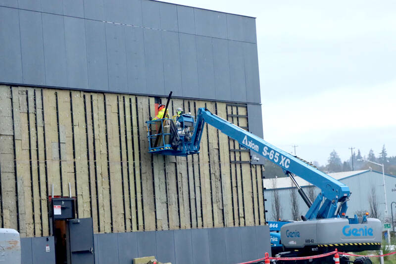 Crews work to remove metal siding on the north side of Field Arts & Events Hall on Thursday in Port Angeles. The siding is being removed so it can be replaced. (Dave Logan/for Peninsula Daily News)