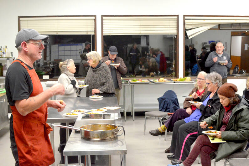Chef Arran Stark speaks with attendees as they eat ratatouille — mixed roasted vegetables and roasted delicata squash — that he prepared in his cooking with vegetables class. (Elijah Sussman/Peninsula Daily News)