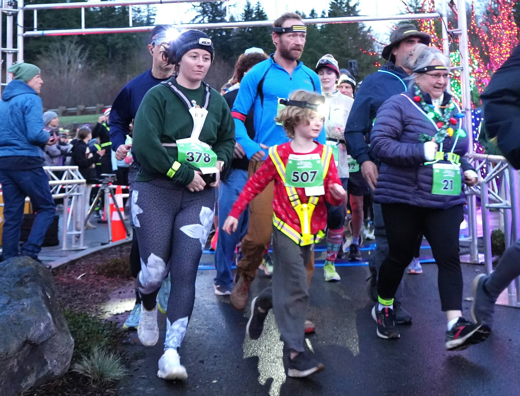 Aaliyah Clark of Poulsbo (378) and Monica Castleberry of Lacey (21) lead a young runner at the start of the Jamestown S'Klallam Glow Run in Blyn late Saturday afternoon. The race had a record-breaking 900 participants this year. (Michael Dashiell/Jamestown S'Klallam Tribe)