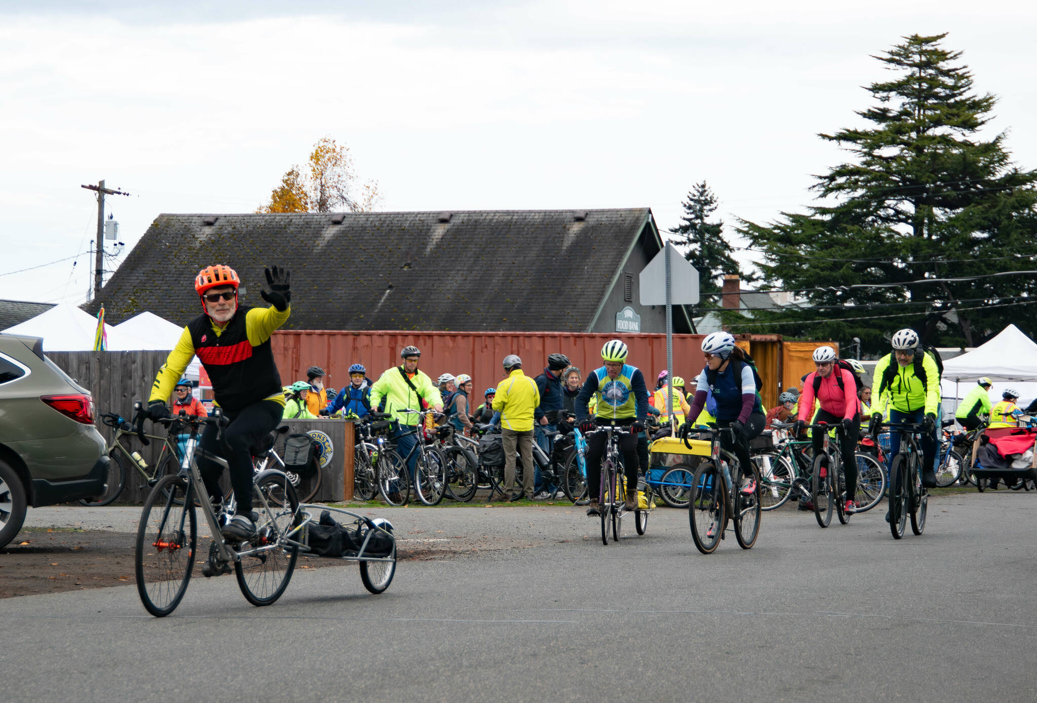 Denny Bellow, left, waves as he departs the Sequim Food Bank to collect food as part of the 15th annual Cranksgiving event on Nov. 22. Cranksgiving drew a record 84 cyclists and resulted in donations to the Sequim Food Bank of more than $6,400 and more than 2,000 pounds of food, Executive Director Andra Smith said. The event was open to riders of all ages and involves swag and prizes donated by local merchants and national bicycle brands. Over the years, it has brought in more than 10 tons of food and more than $27,000 in donations, with participants purchasing food from along Washington Street. (Monica Berkseth/For Olympic Peninsula News Group)