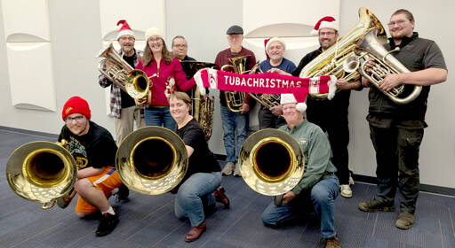 A dozen tuba and euphonium players from the Sequim City Band gather with their instruments and a signature red TubaChristmas scarf as they prepare for this year’s TubaChristmas performance in Port Angeles. (Sharron McClelland/Sequim City Band)