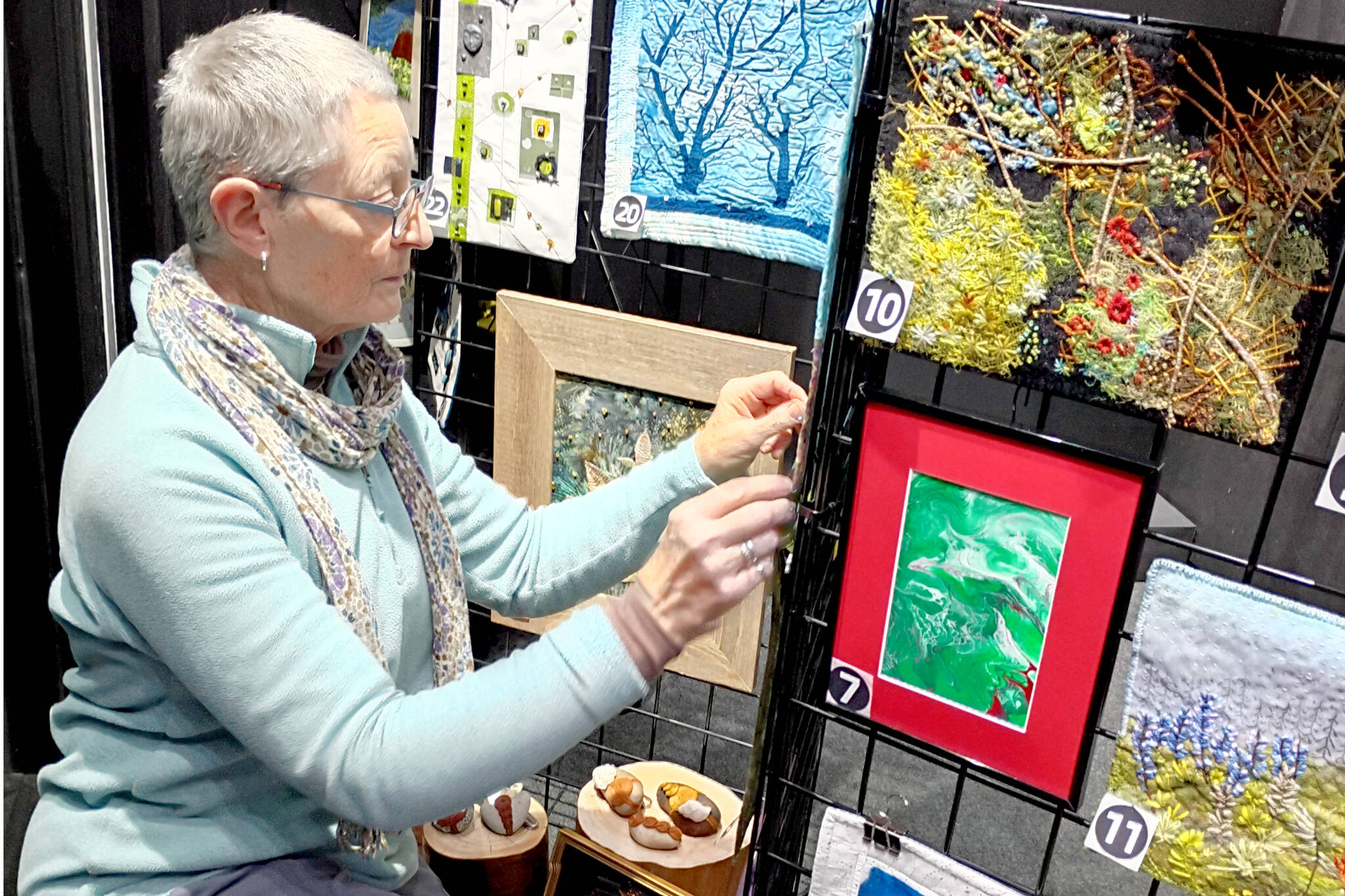 Debra E. Olson, a Port Townsend fiber artist, puts the finishing touches on the “Small But Mighty” exhibit at 675 Tyler St. in uptown Port Townsend.