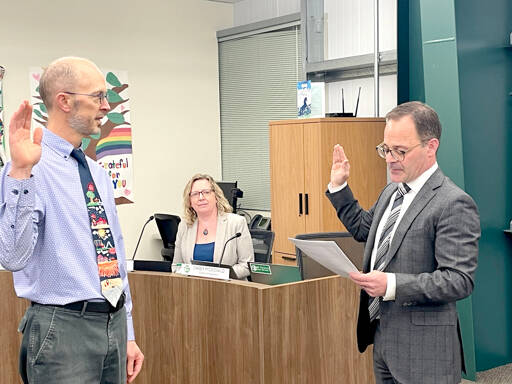 Ned Hammar, left, is sworn in as Port Angeles School District Position 2 director by Clallam County Superior Court Judge Simon Barnhart on Thursday as Superintendent Michelle Olsen looks on. (Paula Hunt/Peninsula Daily News)