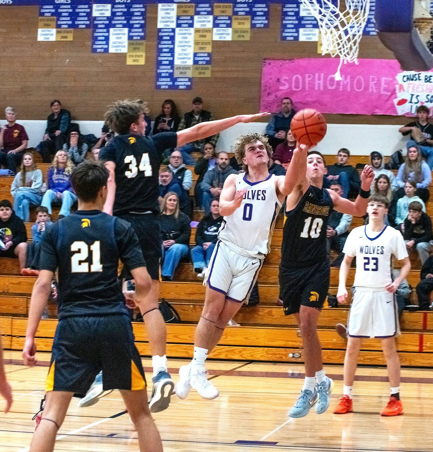 Sequim’s Zeke Schmadeke (0) drives to the rim against Bainbridge on Friday night in Sequim. The Wolves were down by just two points to open up the fourth quarter but lost 67-56. (Emily Matthiessen/for Peninsula Daily News)