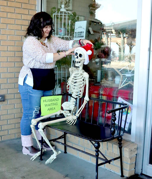 Tippy Munger, an employee at Olympic Stationers on East Front Street in Port Angeles, puts out a welcoming display for holiday shoppers just outside the business’ door every day. She said several men have sat there waiting while their wives shop inside. (Dave Logan/for Peninsula Daily News)