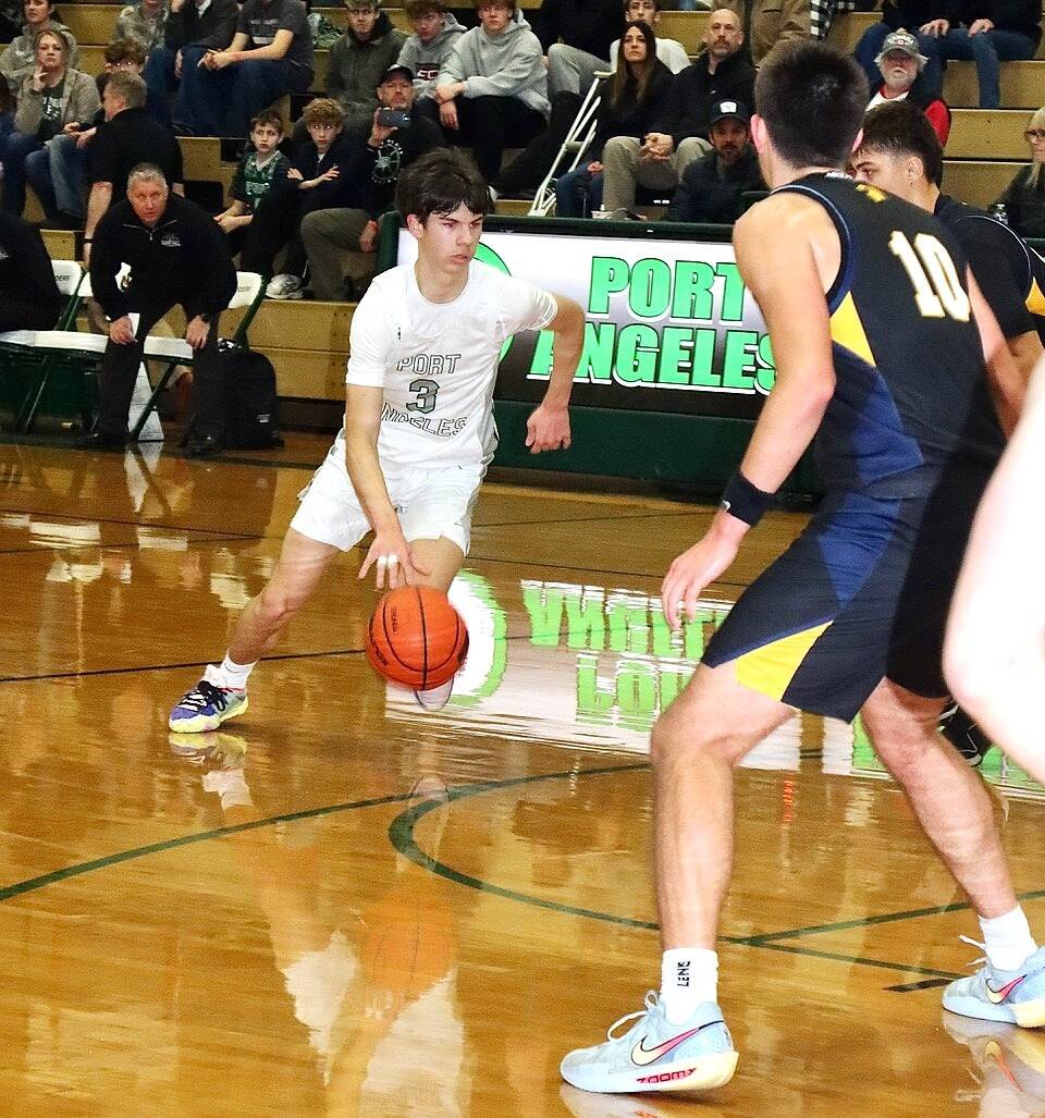 Port Angeles’ Brody Pierce drives the lane against Bainbridge on Friday in Port Angeles. The short-handed Roughriders kept pace with the Spartans until the final three minutes of the first half. (Dave Logan/for Peninsula Daily News)