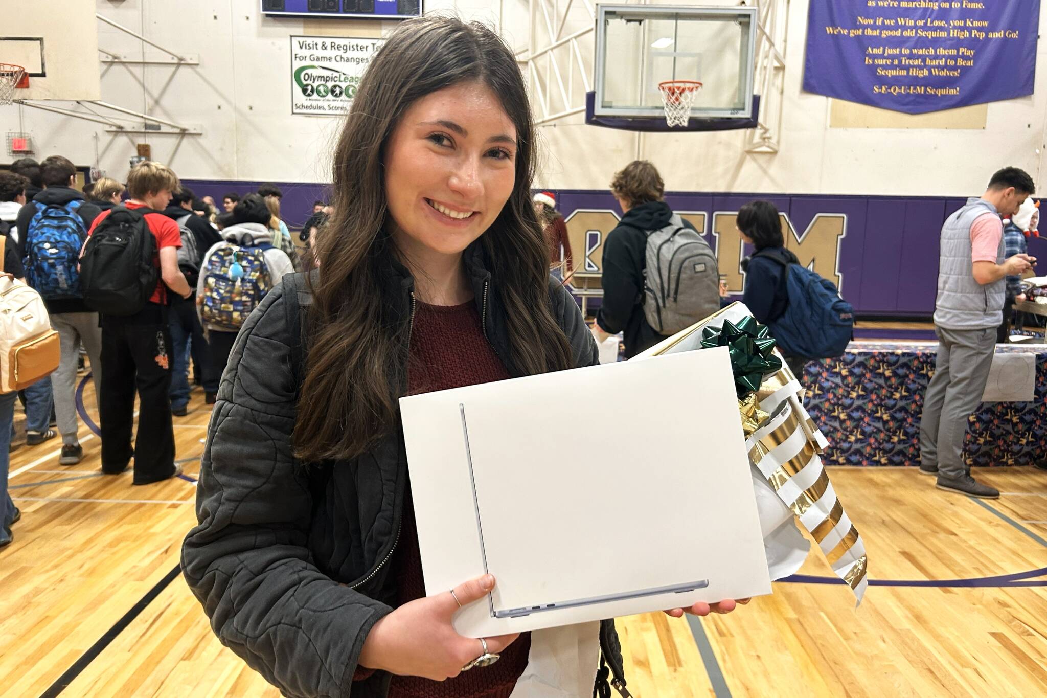 Kendra Dodson holds a new MacBook she received through the Winter Wishes assembly at Sequim High School. “I’m just blown away by my teachers,” she said. “Our staff is very amazing. I feel very lucky.” (Matthew Nash/Olympic Peninsula News Group)