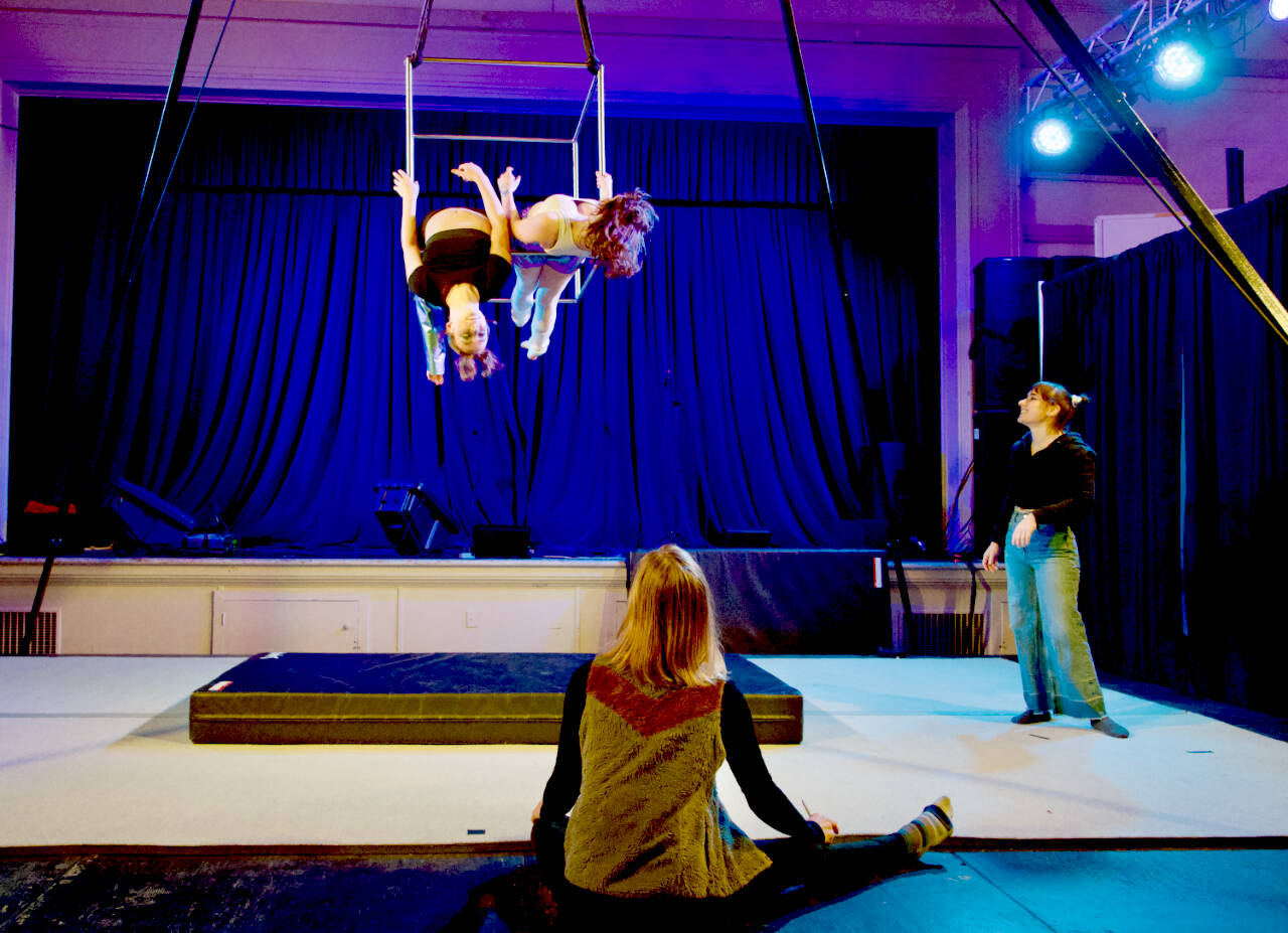 Aspen Mason-Kleeb, left, and Satria McKnight, both of Port Townsend and members of Popup Movement in Port Hadlock, a circus school owned by Sadie La Donna, right, rehearse a routine they were set to perform Wednesday in a performance as part of the First Night event put on by the Production Alliance. Watching is Julia Franz, seated, a rigger for the company. (Steve Mullensky/ for Peninsula Daily News)