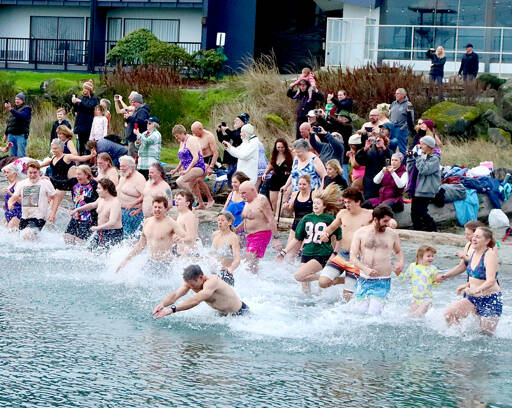 About 100 people dipped three times into the water during the 38th annual Polar Bear Dip on Thursday at Hollywood Beach in downtown Port Angeles. The air and water temperature were both in the low 40s. Each received a certificate for participating, and proceeds benefitted Volunteer Hospice of Clallam County. (Dave Logan/for Peninsula Daily News)