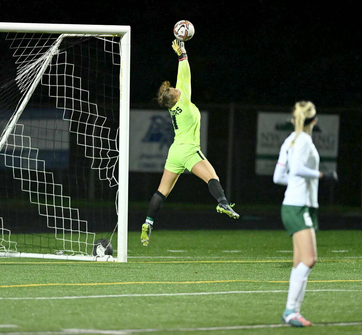Port Angeles’ Kennedy Rognlien makes a leaping save late in the game against Hockinson in the 2A state playoffs, one of 16 saves she made in the game. (Taylor Balkom/The Columbian)