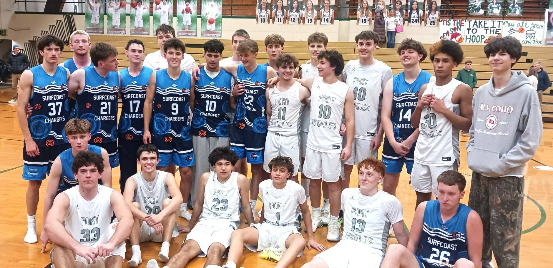 Members of the Port Angeles boys basketball team and the Surfcoast Chargers, a team based in Melbourne, Australia, get together for photos after their game Friday night in Port Angeles. (Pierre LaBossiere/Peninsula Daily News)