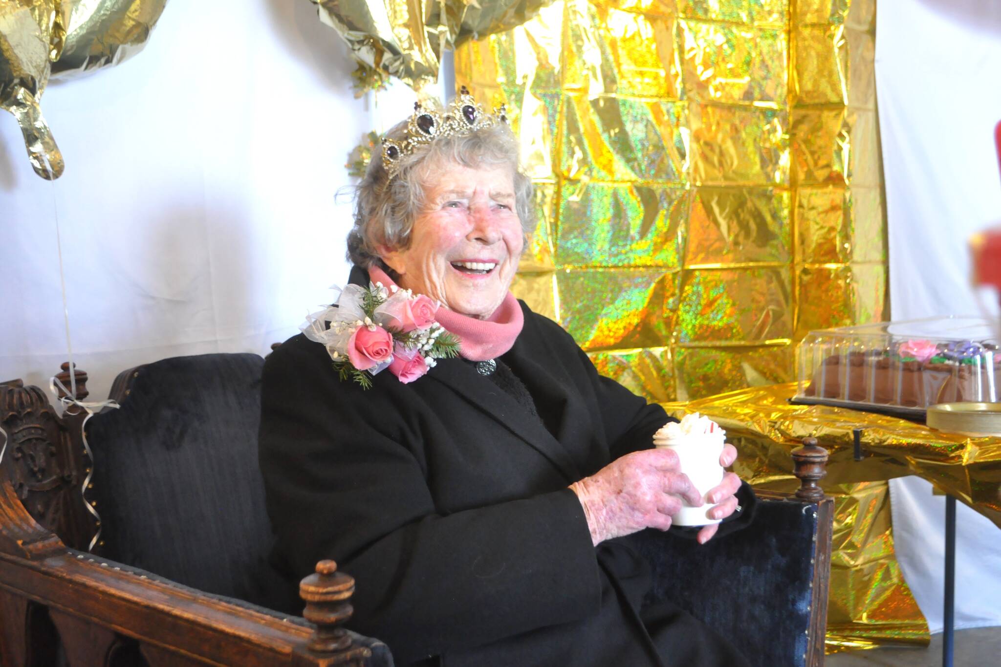 Joan Butler receives a sweet drink as a gift during her 100th birthday party on Dec. 19 at Diamond Point. (Matthew Nash/Olympic Peninsula News Group)