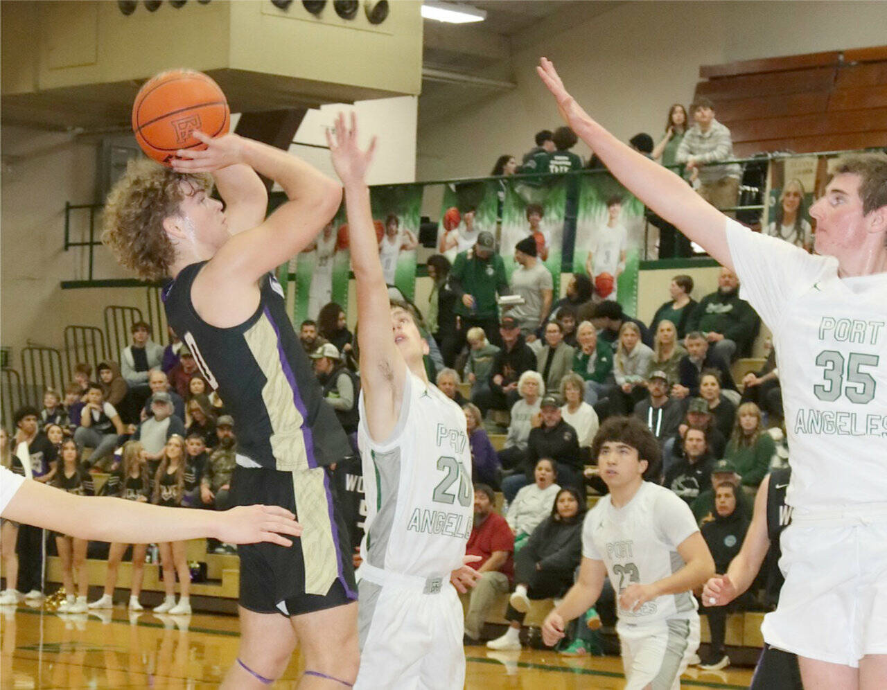 Sequim’s Zeke Schmadeke shoots against the defense of Port Angeles’s Ashton Gedelman (20) and Abe Brenkman (35). Keilar Point (23) is also on the floor. (Dave Logan/for Peninsula Daily News)