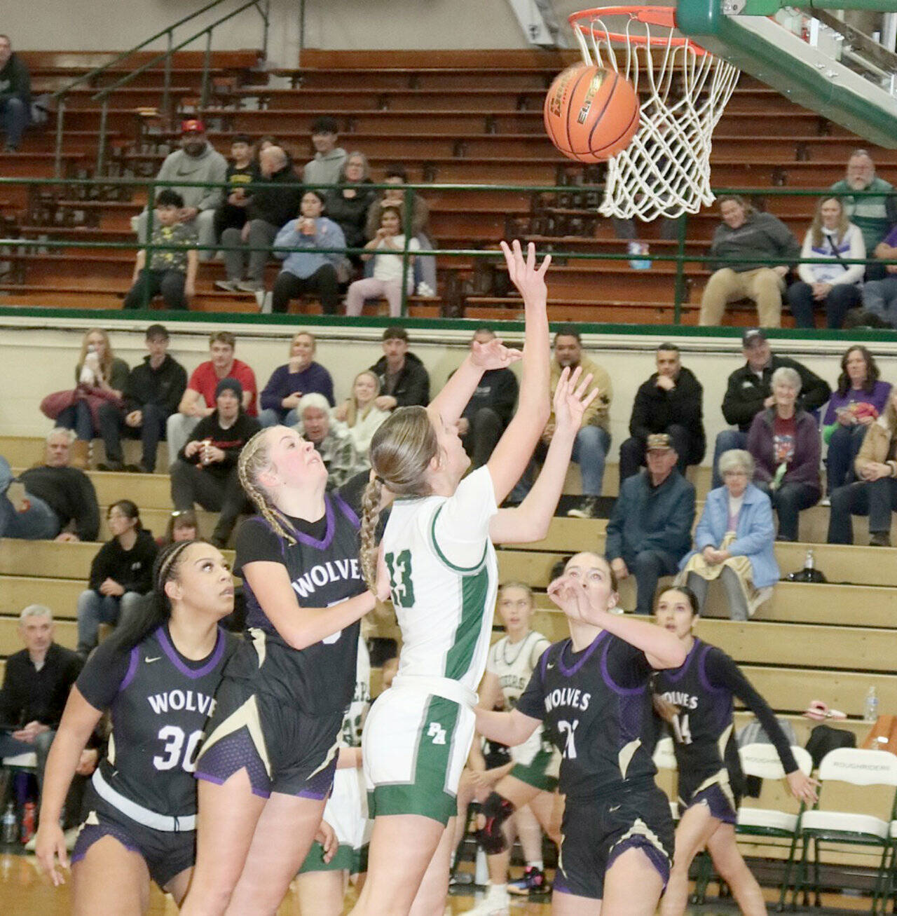 Dave Logan/for Peninsula Daily News
Port Angeles’ Morgan Politika goes up for a shot against Sequim on Tuesday night in Port Angeles. Defending for Sequim is Indi Mixon (30), Kaiya Robinson (5) and Hailey Wagner (21).