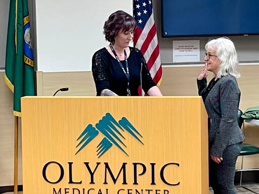 Carleen Bensen, right, is sworn in as Clallam County Hospital District 2 commissioner by Gena Winningham at the Olympic Medical Center’s board of commissioners meeting on Wednesday. New commissioners Gerald Stephanz and Penney Sanders also were sworn in. (Paula Hunt/Peninsula Daily News)