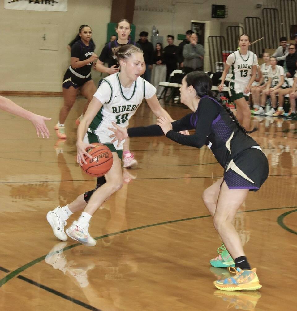 Dave Logan/for Peninsula Daily News
 Port Angeles’ Teanna Clark, pictured driving against Sequim’s Gracie Chartraw in a game Tuesday night, scored nine points in the fourth quarter of the Roughriders’ win over Bainbridge on Wednesday.