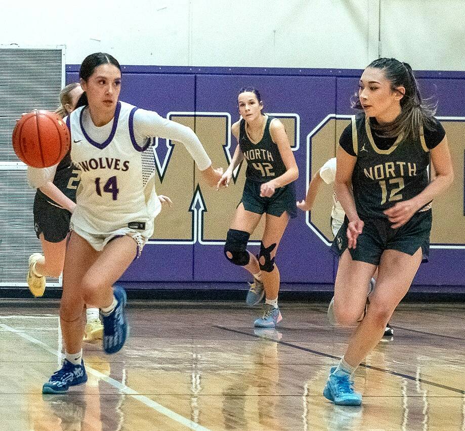 Sequim’s Gracie Chartraw (14) scored 34 points to help lead the Wolves to a 66-40 over league rival North Kitsap on Friday. In on this play are North Kitsap’s Addison Jess (42) and Jasmine Sunnenberg (12). (Emily Mathiessen/for Peninsula Daily News)