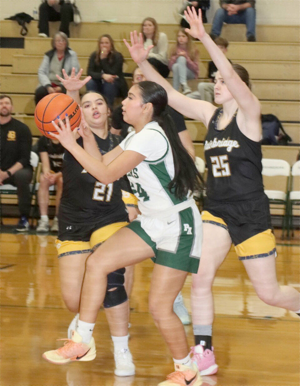 Port Angeles’ Kenzie Moses is defended by Bainbridge Island’s Jordan Gardner (21) and Allie Paulson-Houser (25) on Tuesday in Port Angeles. Moses had a 3-pointer as the Roughriders won 53-46 to remain unbeaten in the Olympic League. (Dave Logan/for Peninsula Daily News)