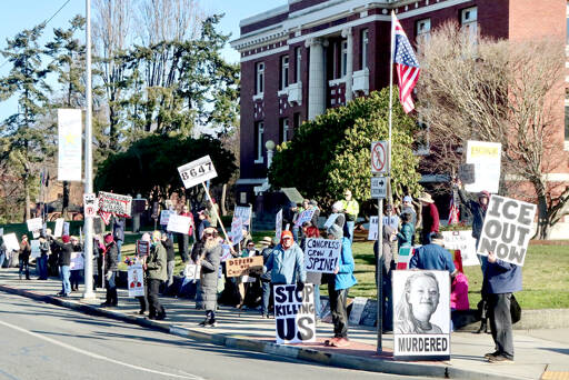 A large group with signs and banners gathers in front of the Clallam County Courthouse on Lincoln Street on Saturday with concerns about the federal Immigration and Customs Enforcement (ICE) agency. A Border Patrol agent shot and killed Alex Pretti, 37, in Minneapolis last week, shortly after an ICE agent fatally shot Renee Good, 37, also in Minneapolis earlier this month. (Dave Logan/for Peninsula Daily News)